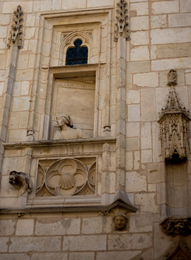 The palace of Jacques Couer in Bourges, these two figures lean out to to look, not at each other but in opposite directions from the windows above the entrance to their palace.