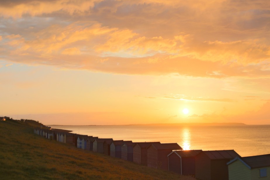 Just before the sun disappeared behind the distant strip of Essex, the view from Tankerton over the huts was  pure colour, the grass turning russet.