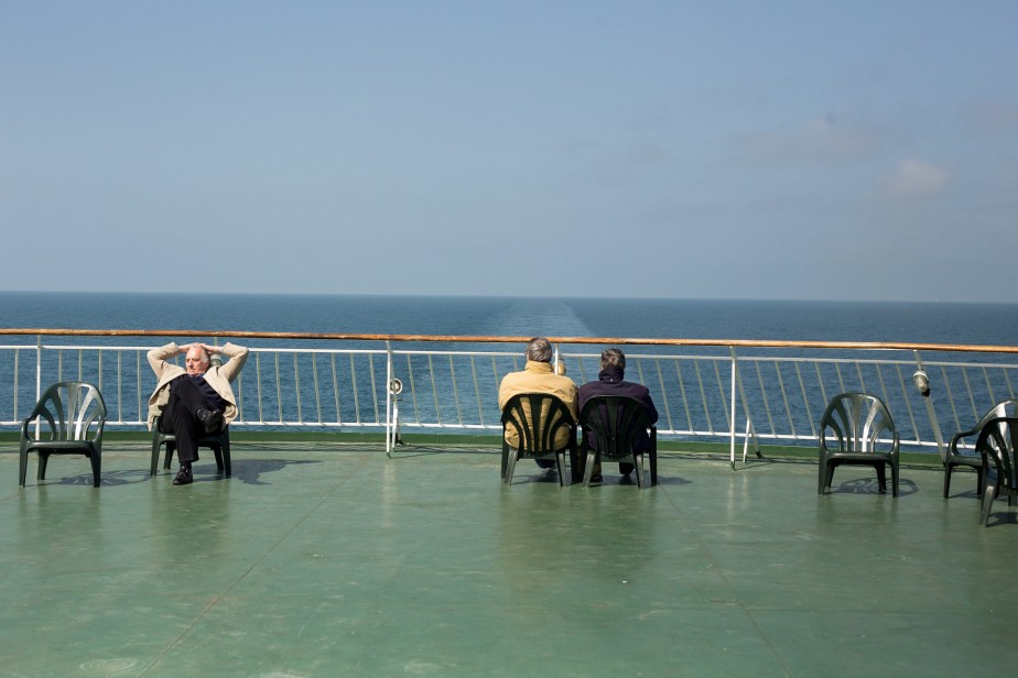 The men have escaped their women, who are keeping warm and dry below decks.